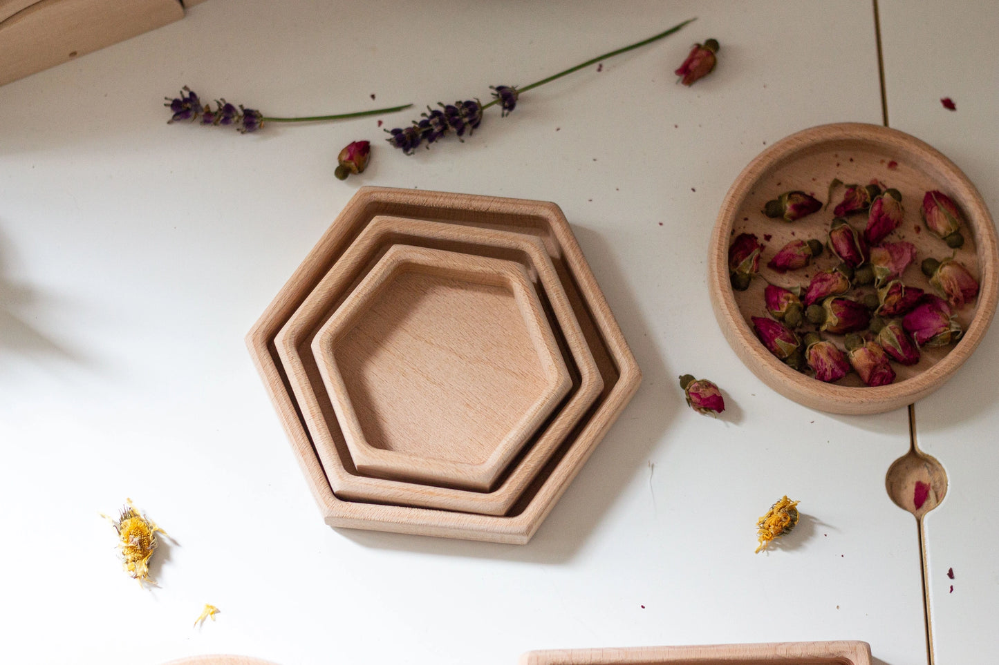 Stacked wooden hexagon sorting trays with flower petals in three sizes made of natural beech wood