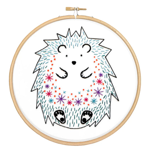 Embroidery hoop with a colorful hedgehog design on a white background