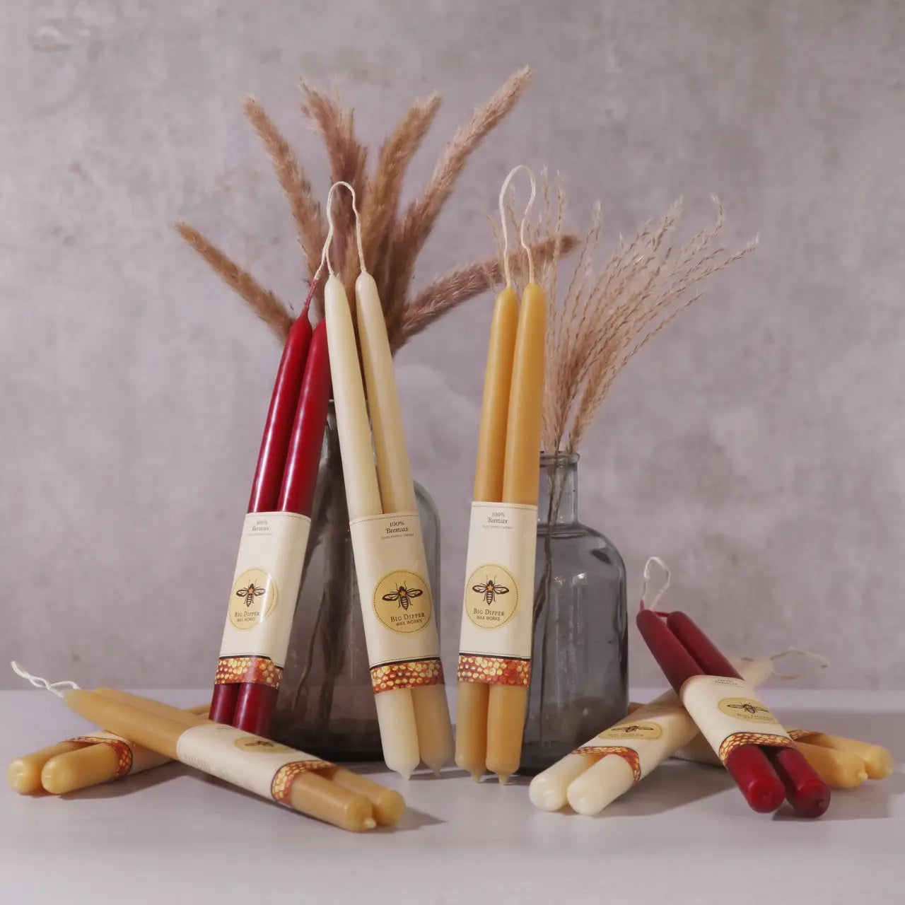 Selection of Beeswax Taper Candle Pairs with Tall Grasses in a Vase