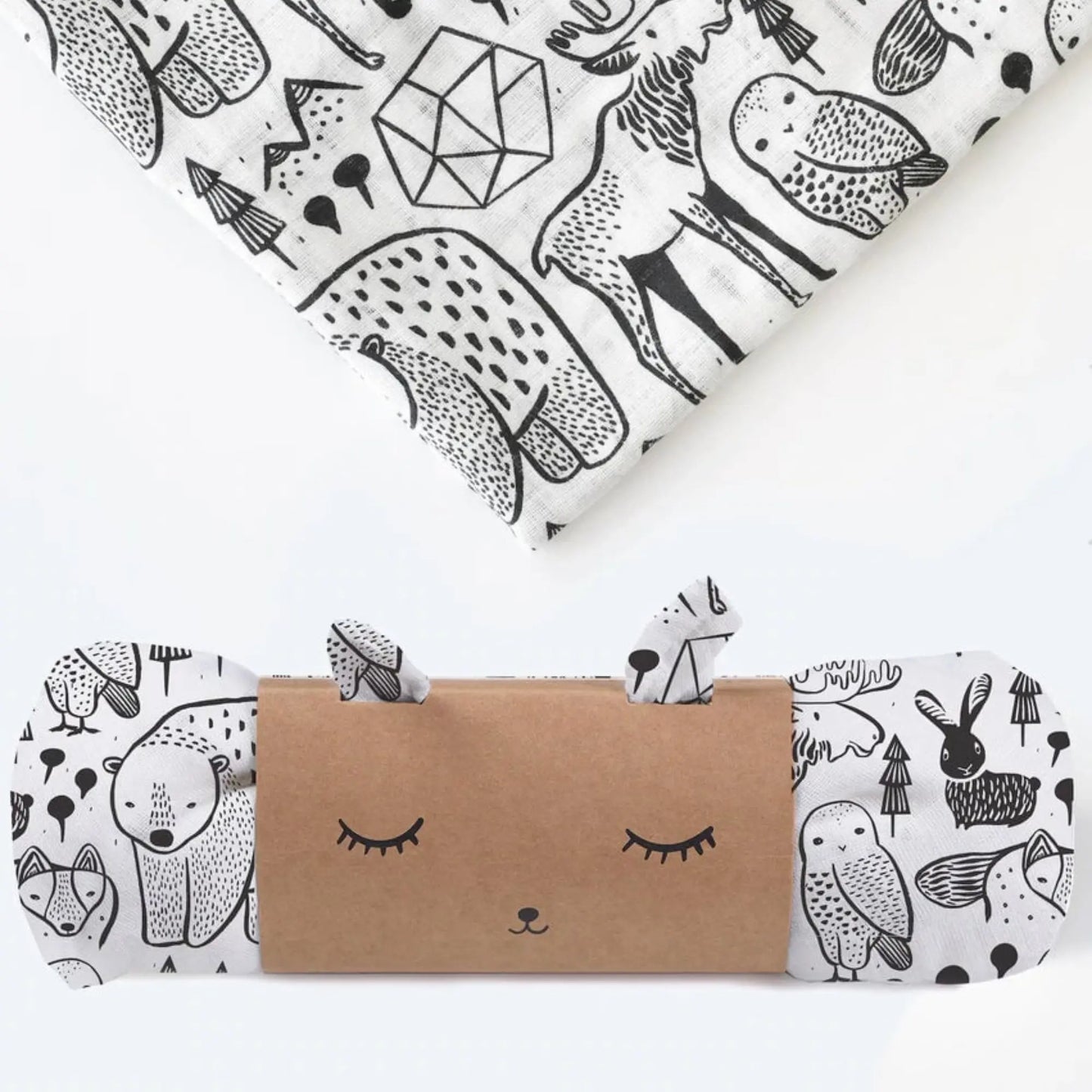 Two organic cotton muslin swaddles with black and white Nordic forest print, one rolled and one folded