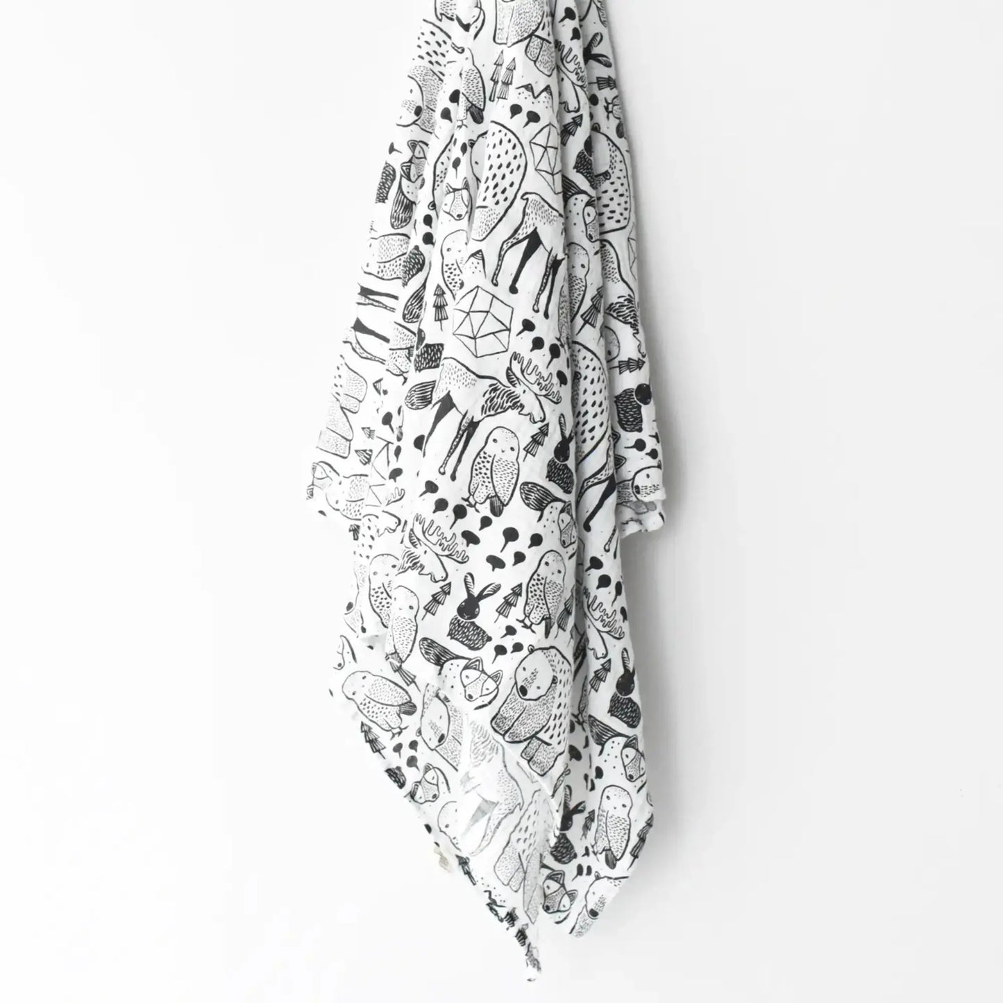 White baby swaddle with black Nordic animal pattern on a white hanging on wall hook