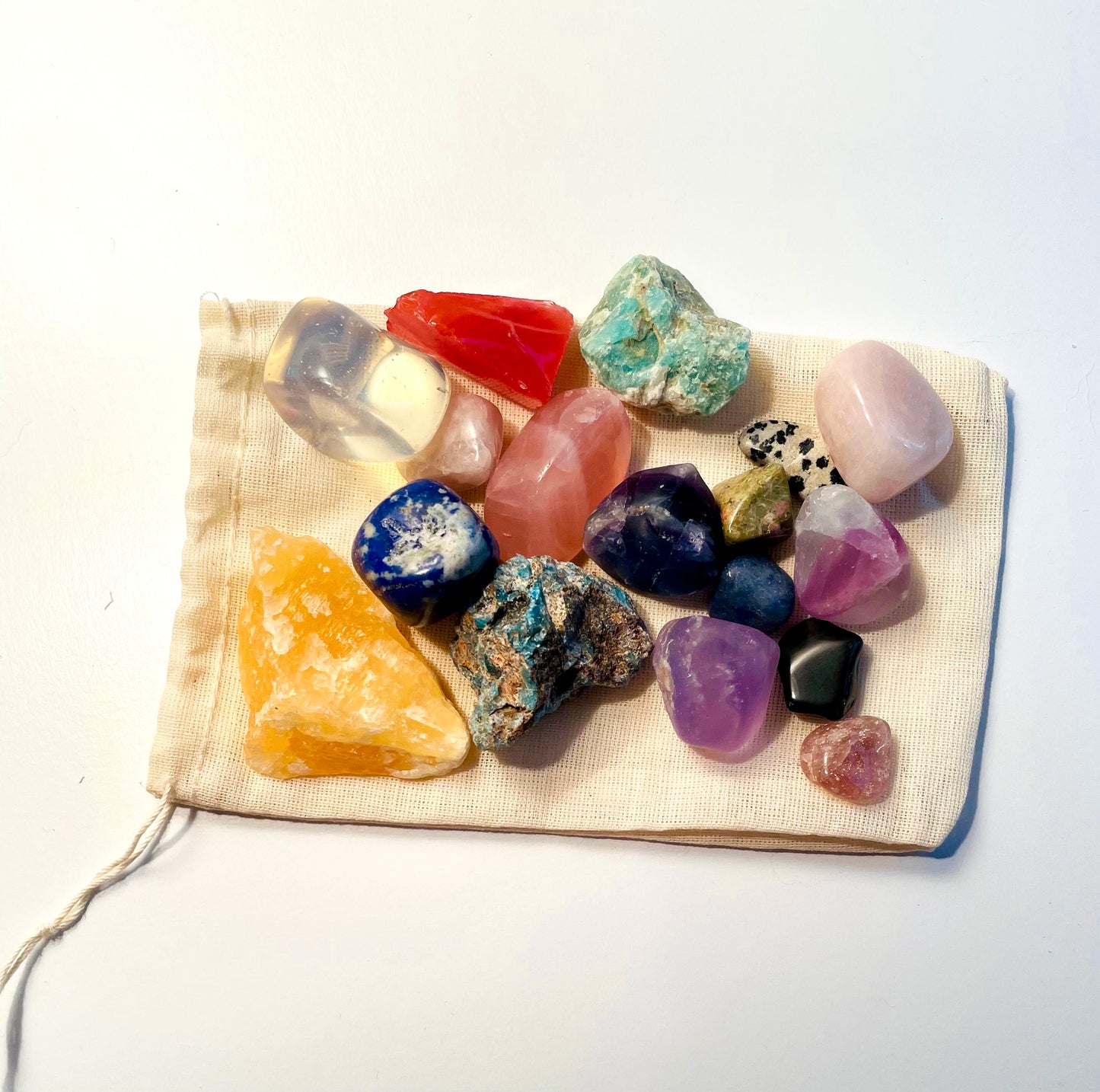 Top down view of rocks polished and raw on a drawstring bag