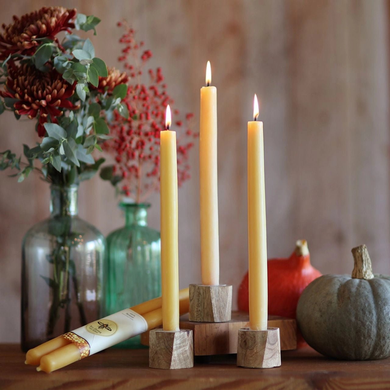Tall Beeswax Taper Candles in Candle Holders on Tabletop with Pumpkins