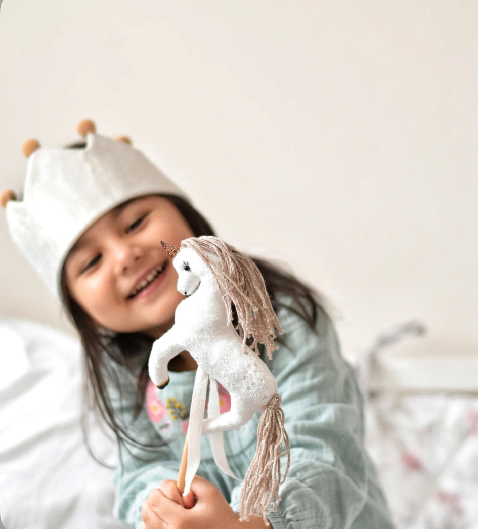 Little Girl Wearing Play Crown and playing with a Magical Unicorn Wand