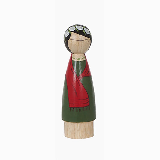 Wooden figurine with a green dress and red shawl on a white background