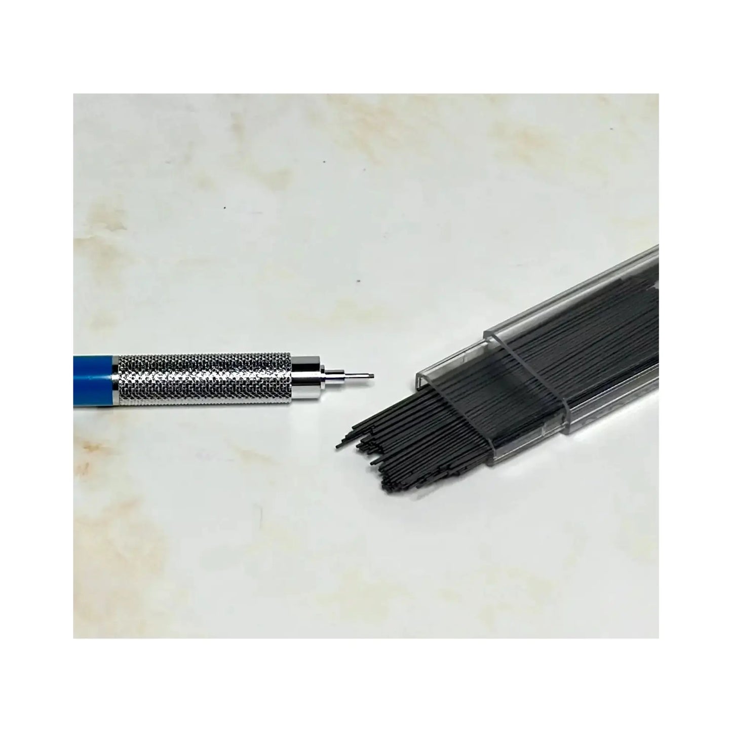 Close up of mechanical pencil tip and container with extra leads