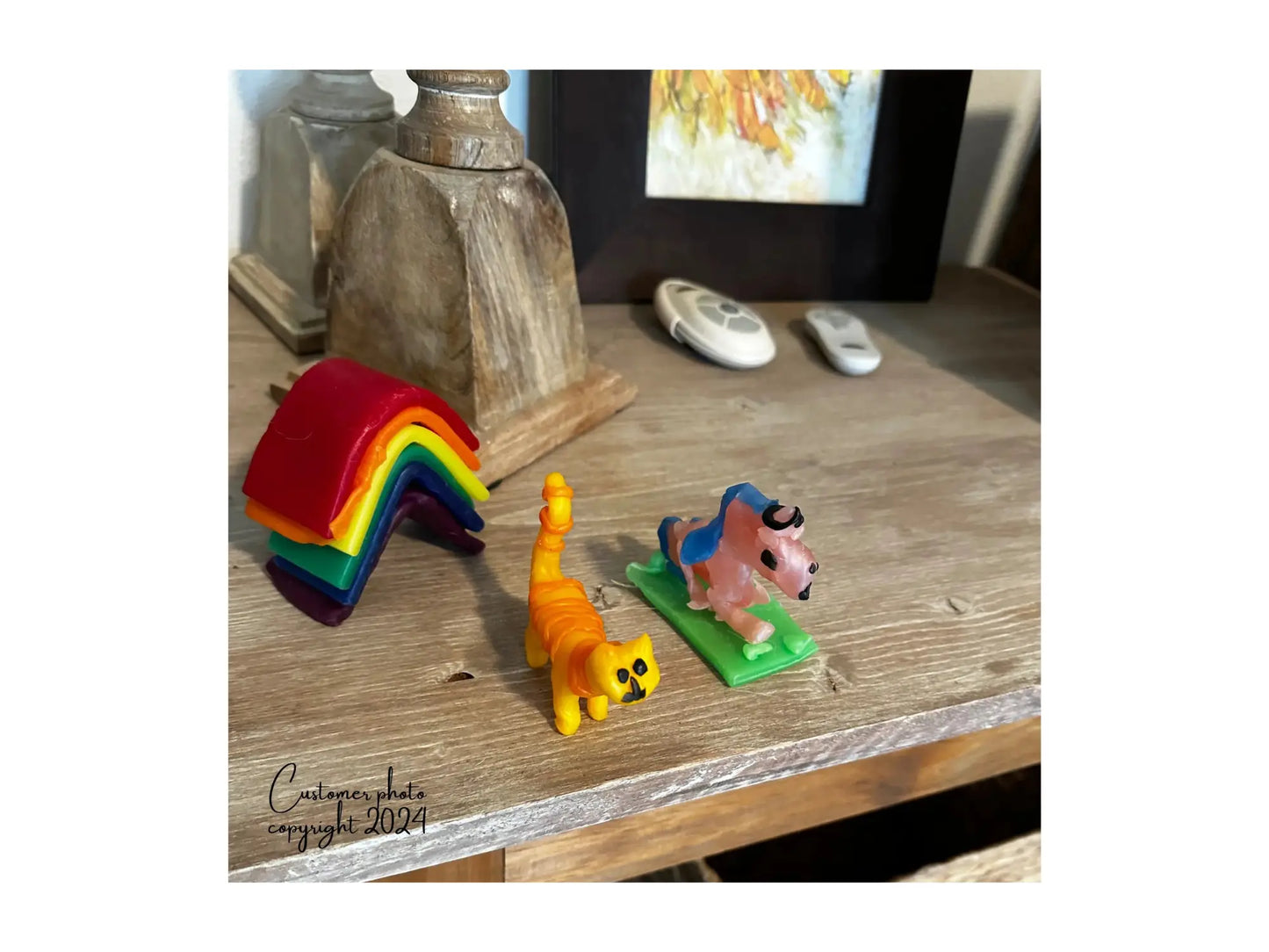 A Modeling Beeswax Rainbow, Yellow and Orange cat and pink and blue unicorn on a table top