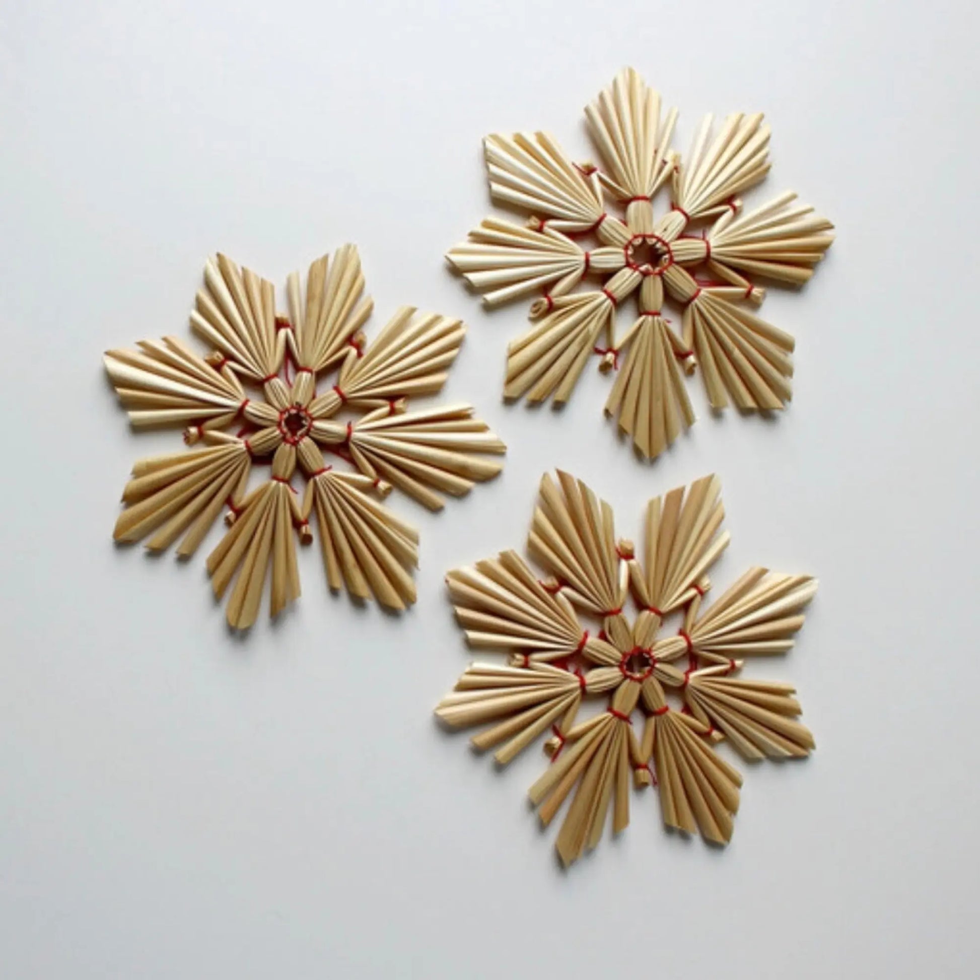Three decorative Swedish Straw ornaments on a light background