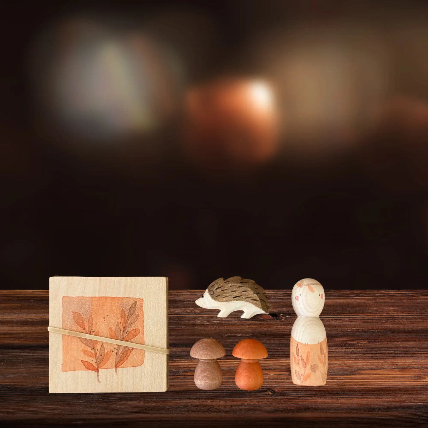 Wooden figurines and a box on a wooden surface with a dark background