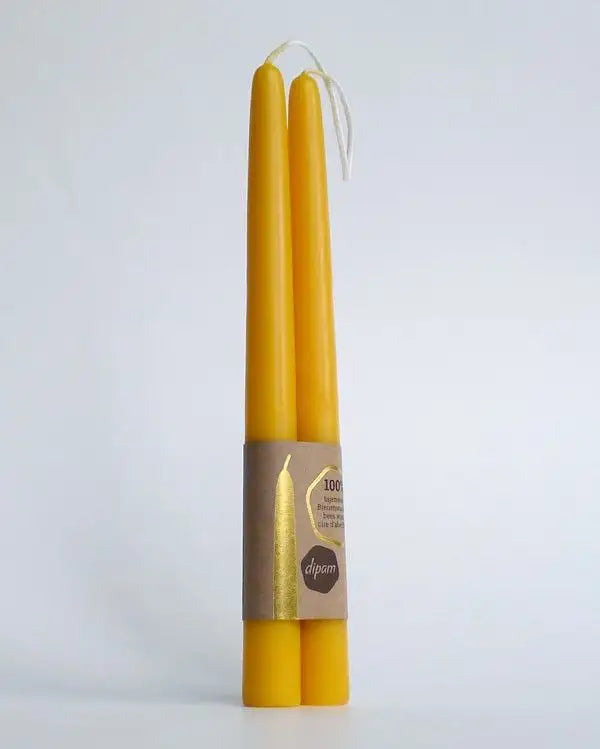 A pair of Dipam hand-dipped 100% beeswax taper candles in golden hue